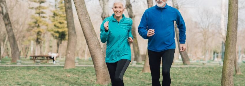 An elderly couple jogging in the woods with natural energy boost from NAD supplementation.