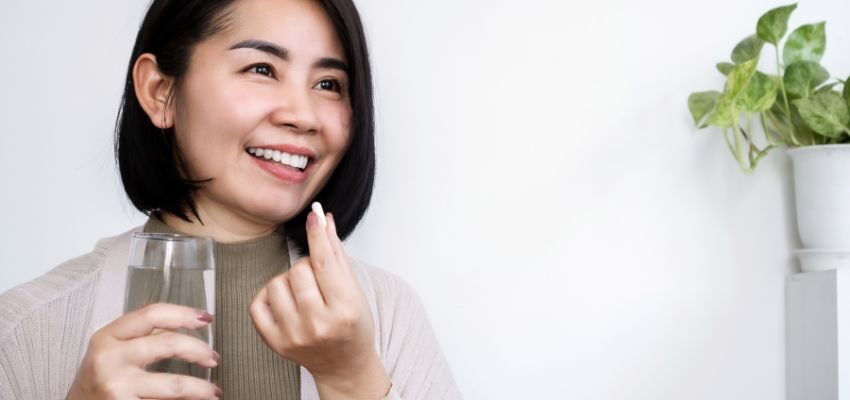 The woman is happy while taking anti-aging supplements.