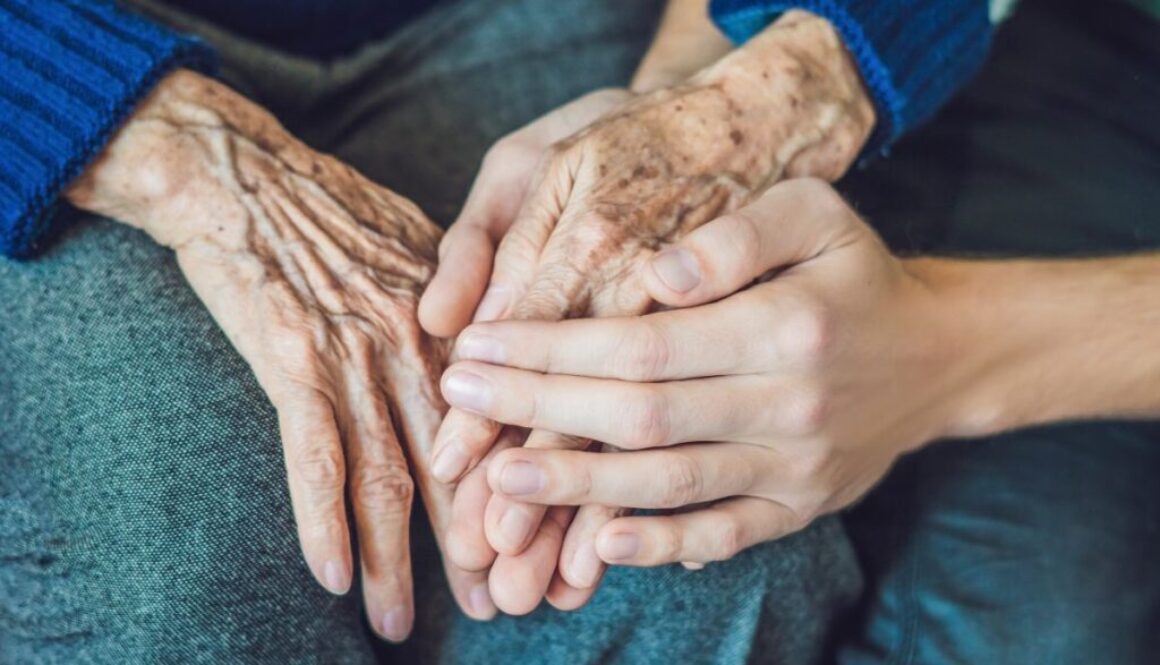 The daughter is holding her mother's hands.