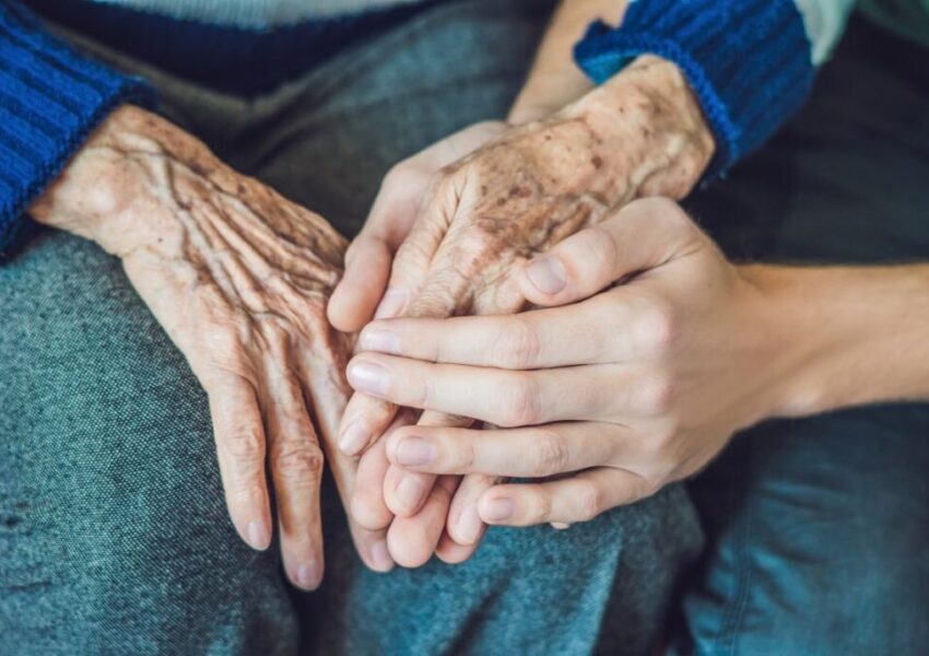 The daughter is holding her mother's hands.