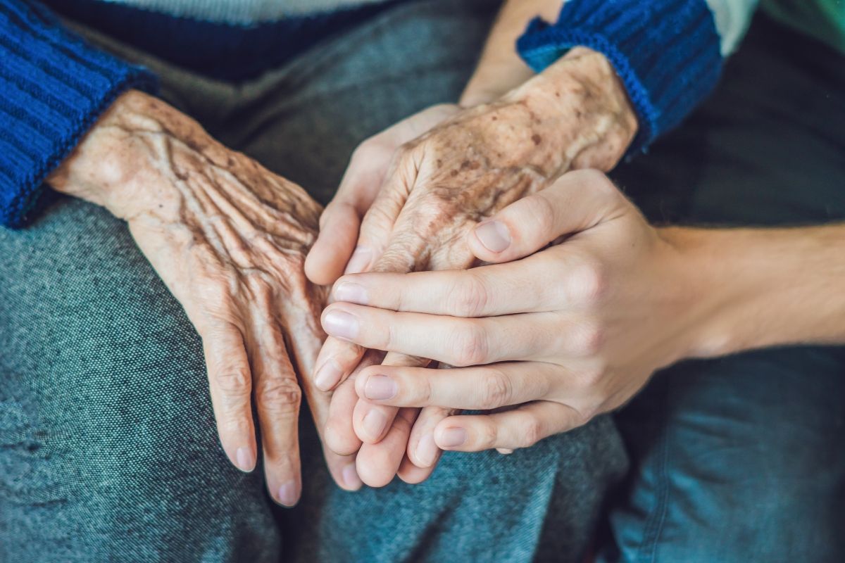 The daughter is holding her mother's hands.