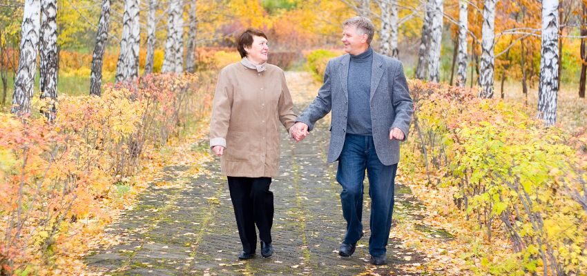 The aged couple happily walks together to stay healthy.