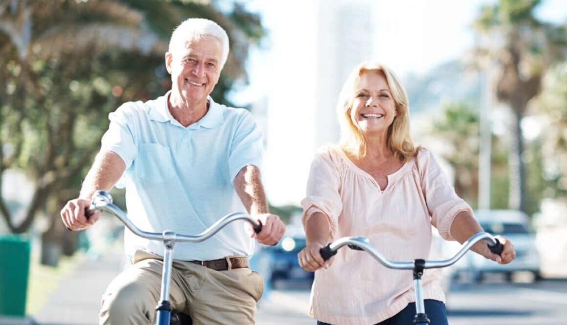 Two elder people on a bike displaying healthy aging tactics