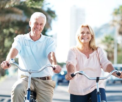 Two elder people on a bike displaying healthy aging tactics