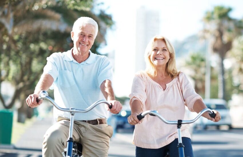 Two elder people on a bike displaying healthy aging tactics