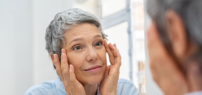 An older woman in a mirror displaying healthy aging tactics