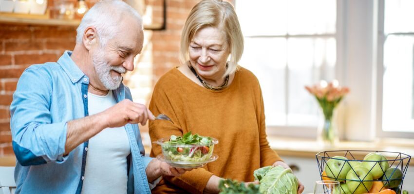 An older couple eating healthy food as part of healthy aging tactics