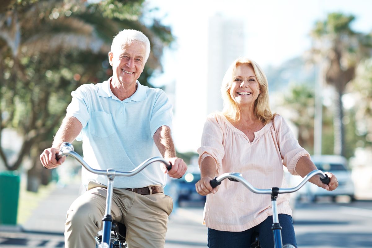 Two elder people on a bike displaying healthy aging tactics